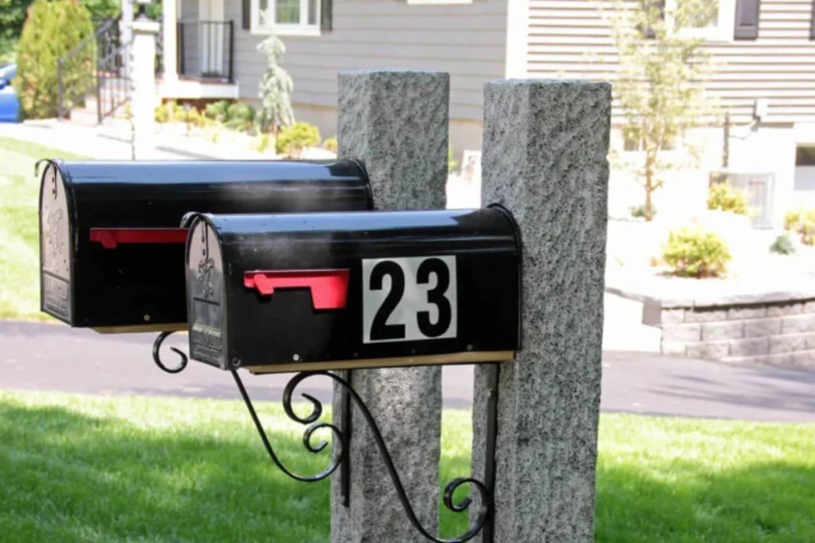 Two granite posts holding up black mailboxes